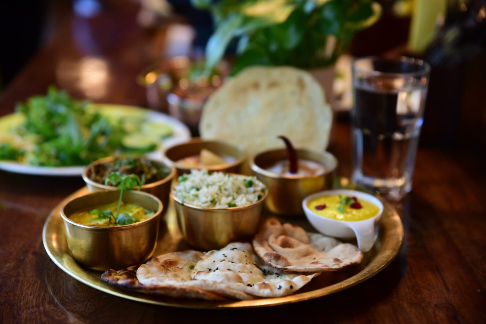 A closeup shot of an Indian tasty food called "Marwari Veg Thali" on the wooden table
